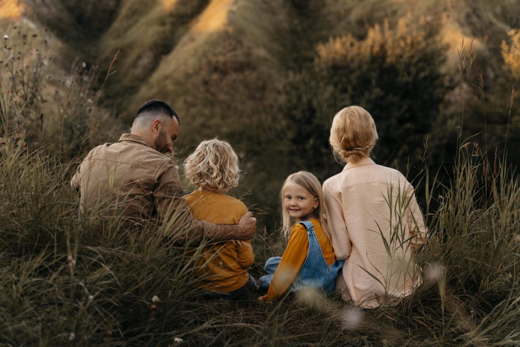 Calming Transformations Counseling - a family of four looking a mountain view with the little smiling girl looking back - therapy for military families