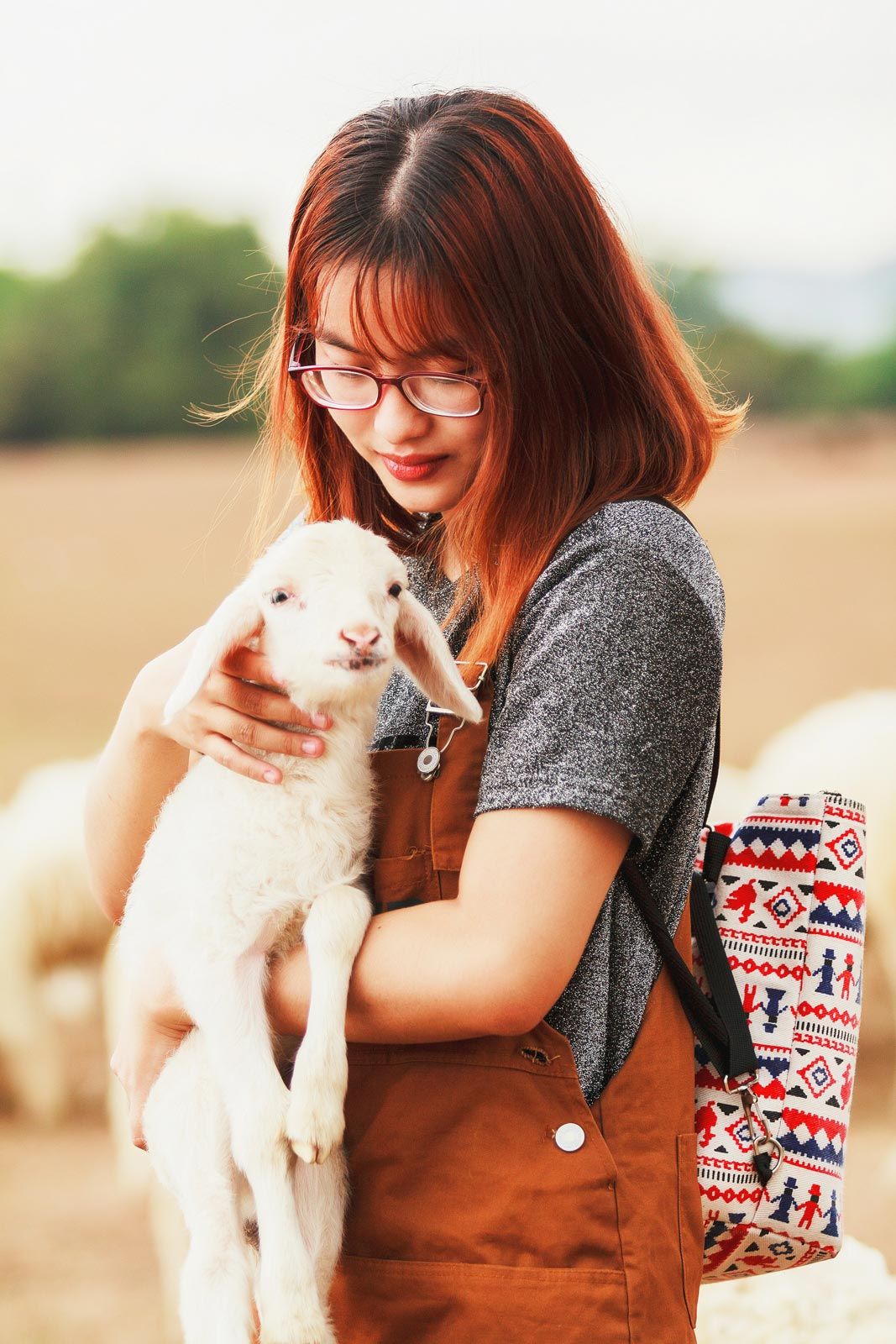 Calming Transformations Counseling - a woman holding a lamb - telehealth therapy