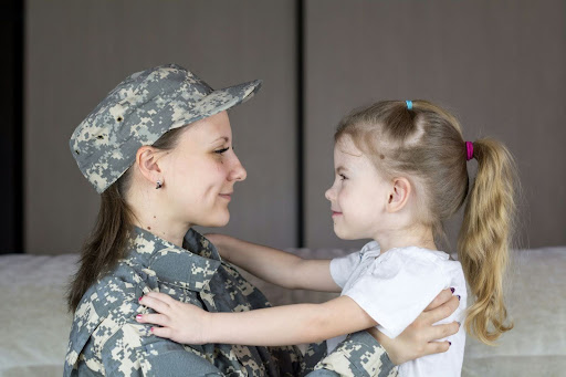 Military mother hugging daughter